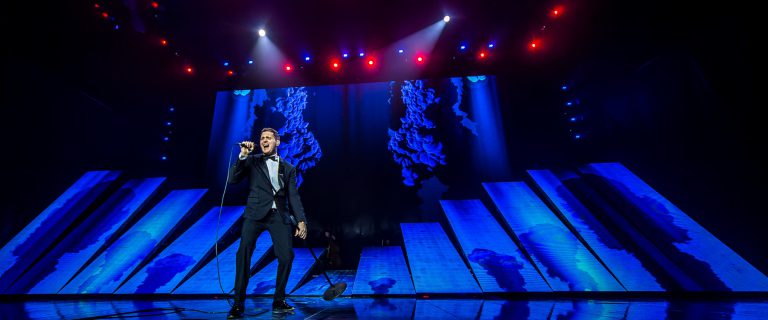 Michael Buble on the stage of the To Be Loved Tour with a giant LED screen, 60 feet x 30 feet in the background